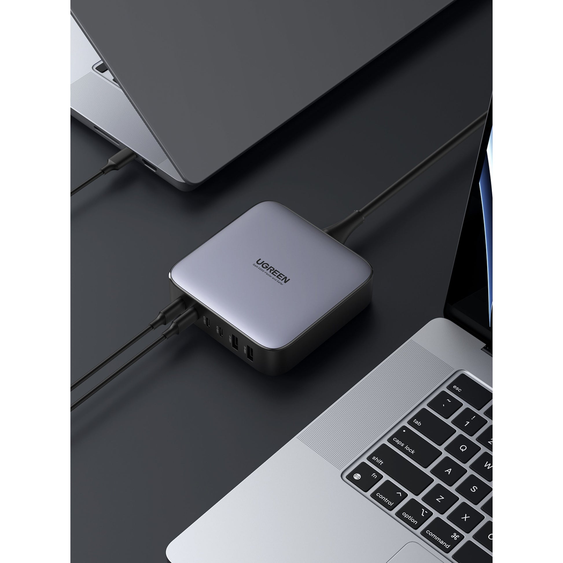 Ugreen Kraftfuld Multilader 6 porte 200 W sølv tilsluttet til laptops, flere kabler i siden.
