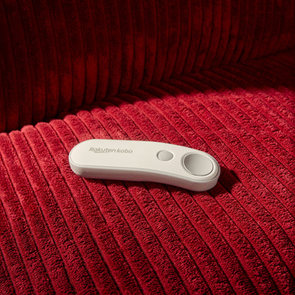 Kobo Trådløs sideomskifter med to knapper til Kobo e-læser, vist på rød fløjlsstof sammen med en Kobo e-læser.