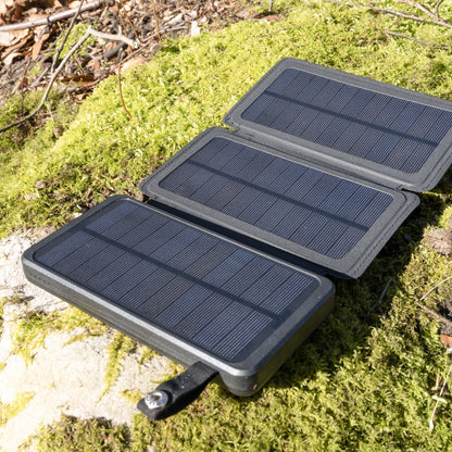 Linocell Powerbank med solcelleopladning 20W 8000mAh, bærbar og foldbar med tre solpaneler på grøn mos.