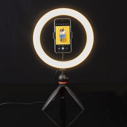 Nedis Ring Light 10" ringbelysning på stativ med smartphone monteret, til kvinder smiler på telefonskærmen.