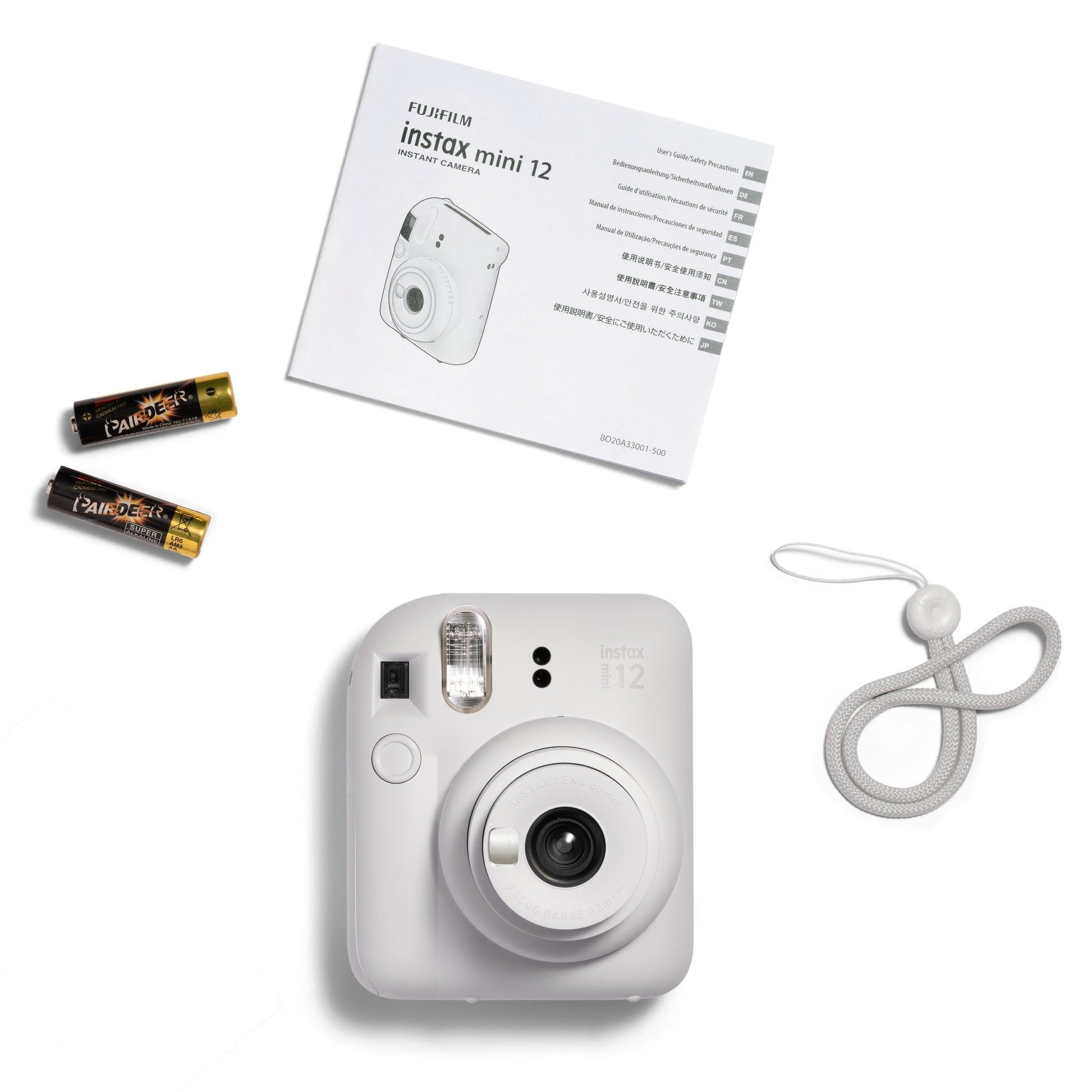 Fujifilm Instax Mini 12 kamera hvid med to AA-batterier, rem og brugervejledning.
