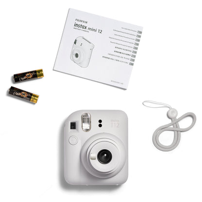 Fujifilm Instax Mini 12 kamera hvid med to AA-batterier, rem og brugervejledning.