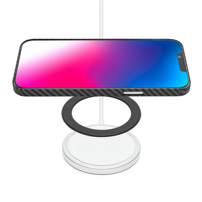 Smartphone liggende vandret på Linocell Magnetisk adapter til trådløs opladning, rund MagSafe lader med sort ring over basen.