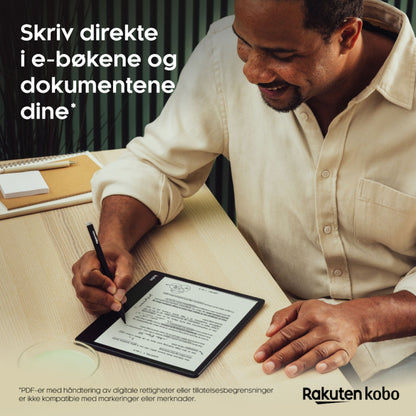 Kobo Elipsa 2E e-bogslæser med Kobo Stylus 2, mand skriver på skærmen, laptop og notesbog ved siden af.