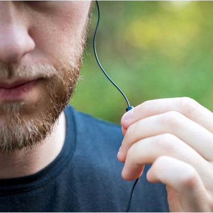 Koss Porta Pro 3.0 on-ear headset med indbygget mikrofon, sort, ses i profil ved øret på mand iført sort trøje.