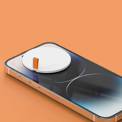 Smartphone med stor hvid rund rensepad og lille orange tap fra 20-i-1 rengøringskit på skærmen, orange baggrund.