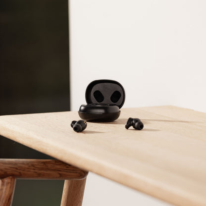 Nomadelic Solo 300 støjreducerende true wireless øretelefoner sort med silikonepropper og opladeetui bagved.