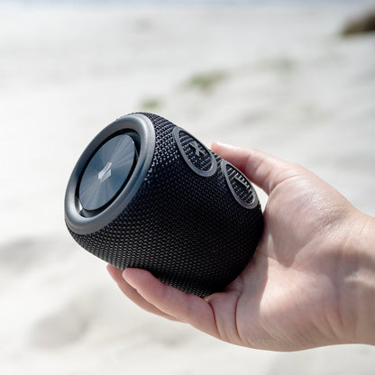 Nomadelic Loud 705 vandtæt Bluetooth-højttaler sort, cylinderformet med kontrolknapper og Bluetooth 5.0, håndholdt.