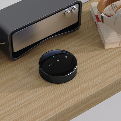 WiiM Mini sorterer lydstreamere med touchknapper til lydstyrke og afspilning, trådløs Hi-Res Audio, placeret på træhylde.