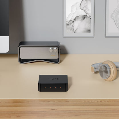 Sort trådløs router, grå WiiM For lydstreamer til hi-res audio, beige over-ear hovedtelefoner, del af computerskærm.