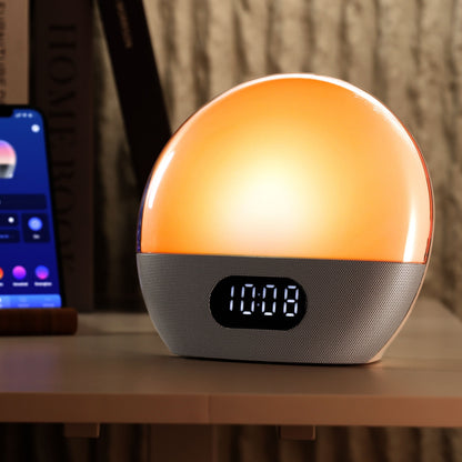 Wiim Vækkeur med wake-up light, solopgangssimulering, orange lys, digitalt 10:08 display ved siden af smartphone og bog.