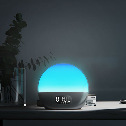 Wiim Vækkeur wake-up light med blå kuppel, digitalt display viser 7:00, placeret på mørkt bord.