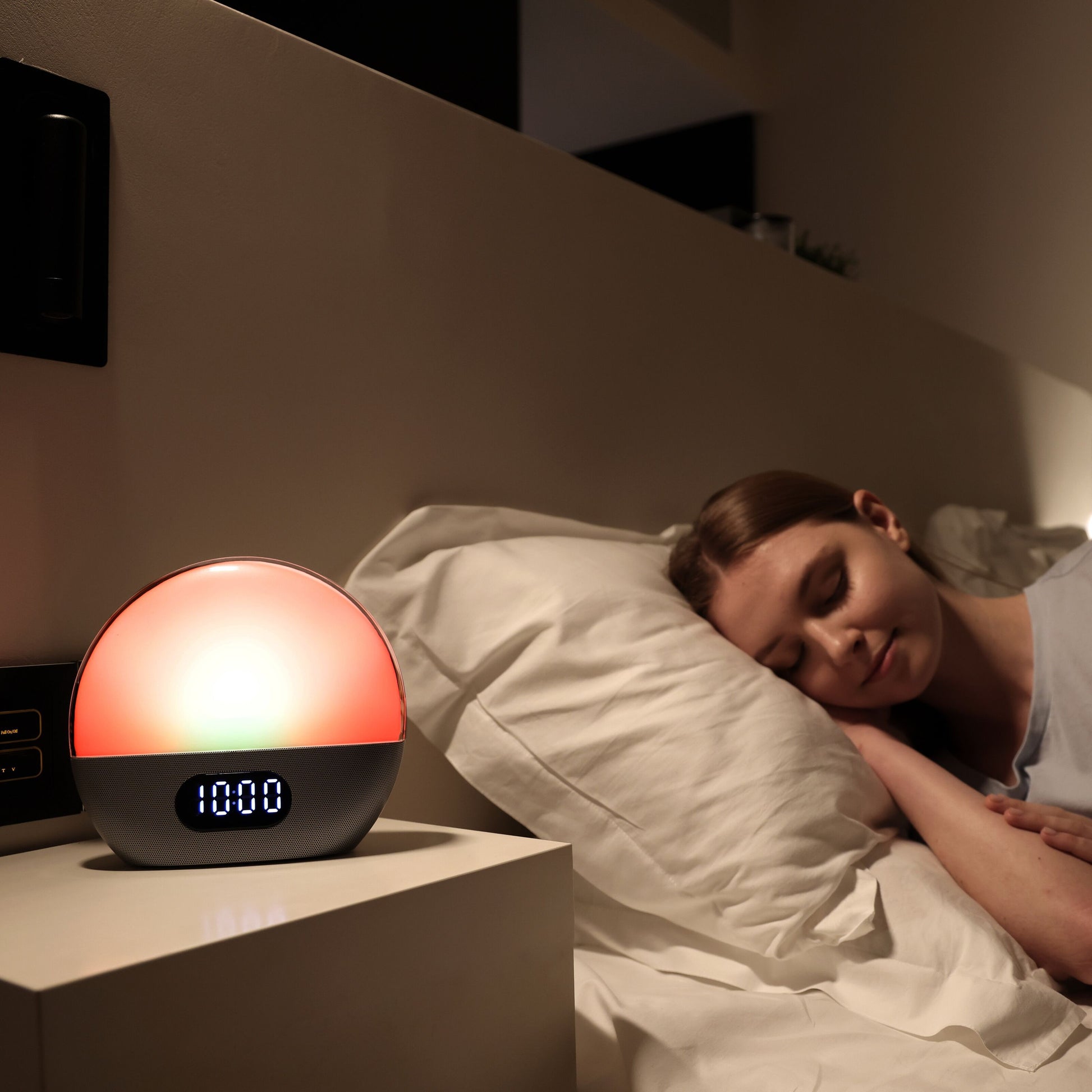 Wiim WiiM Vækkeur wake-up light viser 10:00 og udsender varm orange glød med solopgangssimulering på natbord.