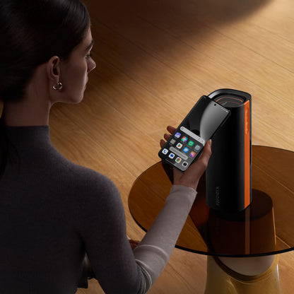 Xiaomi Sound Party bærbar Bluetooth-højttaler 50 W sort IP67 ved siden af smartphone med synlige appikoner.