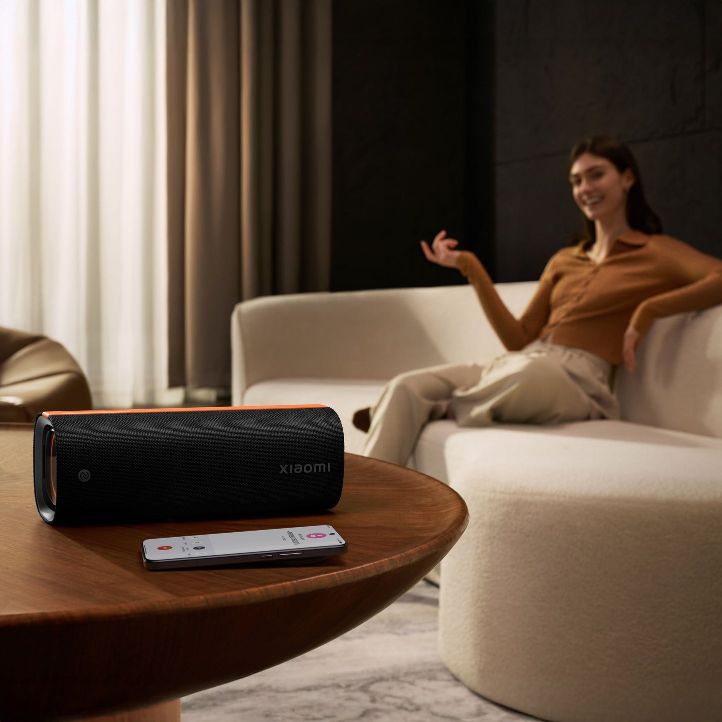 Xiaomi Sound Party bærbar Bluetooth-højttaler 50 W IP67 vandtæt sort på træbord ved siden af smartphone.