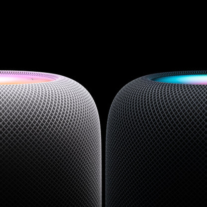 Apple HomePod Midnat smart højttalere, mesh-overflade, én med flerfarvet top, én i blågrøn, sort baggrund.