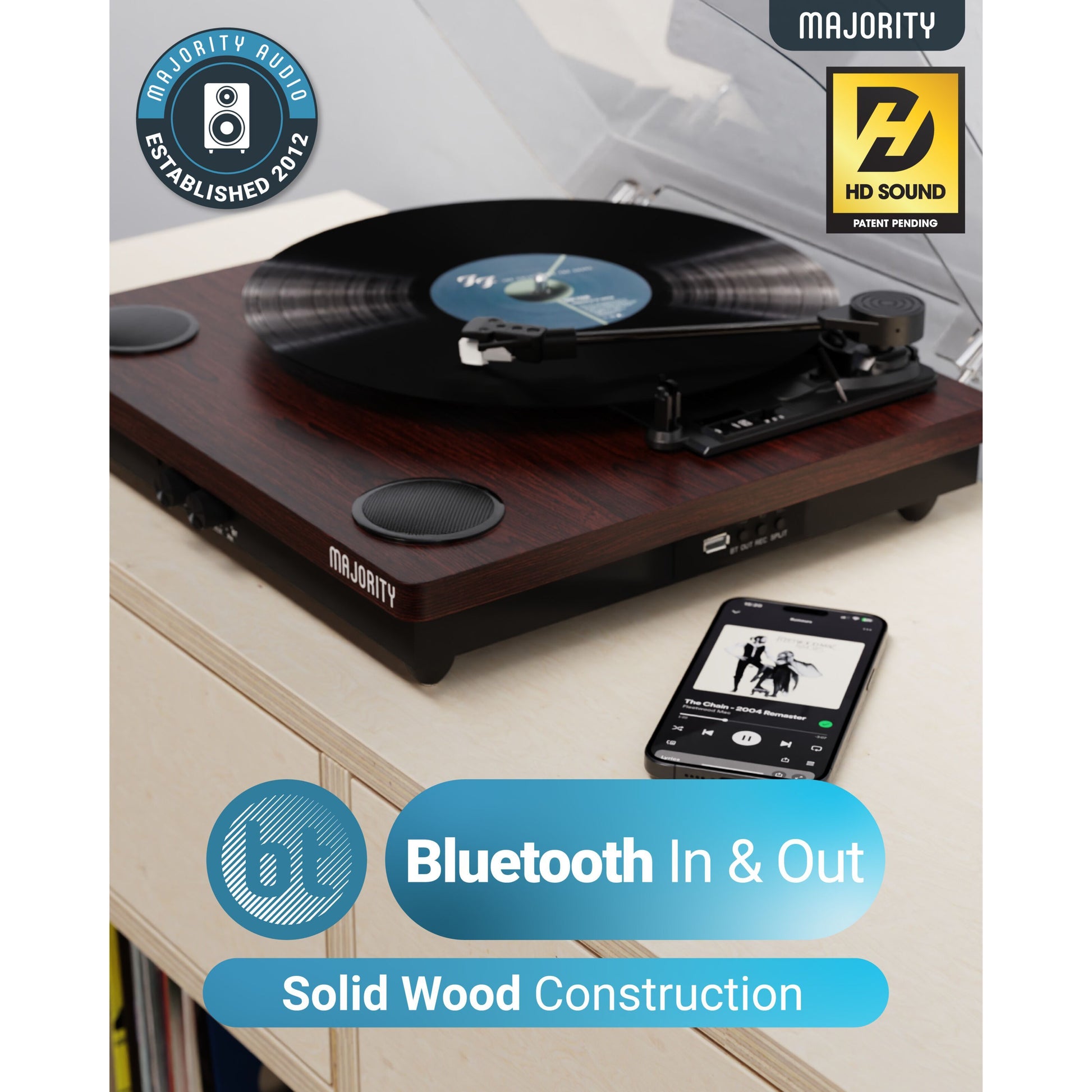 Majority Pladespiller med bluetooth, mørkt træ, indbyggede stereo-højtalere, Bluetooth In  Out, HD Sound, smartphone ved siden af.