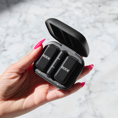 Røde Trådløs mikro lyn trådløse mikrofoner i sort etui, grøn indikator, hånd med lyserøde negle.