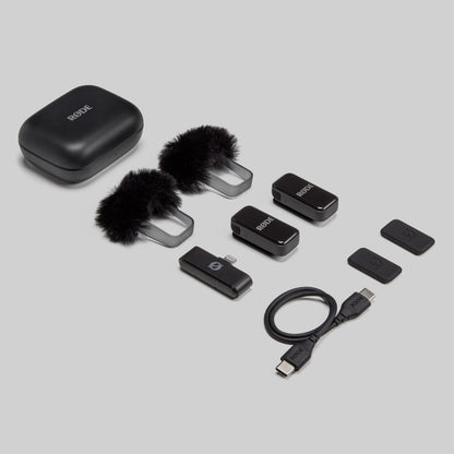 Røde trådløst mikrofonsæt med opladeetui, 2 furry vindskærme, 2 transmittere, modtager, klip og kabler.
