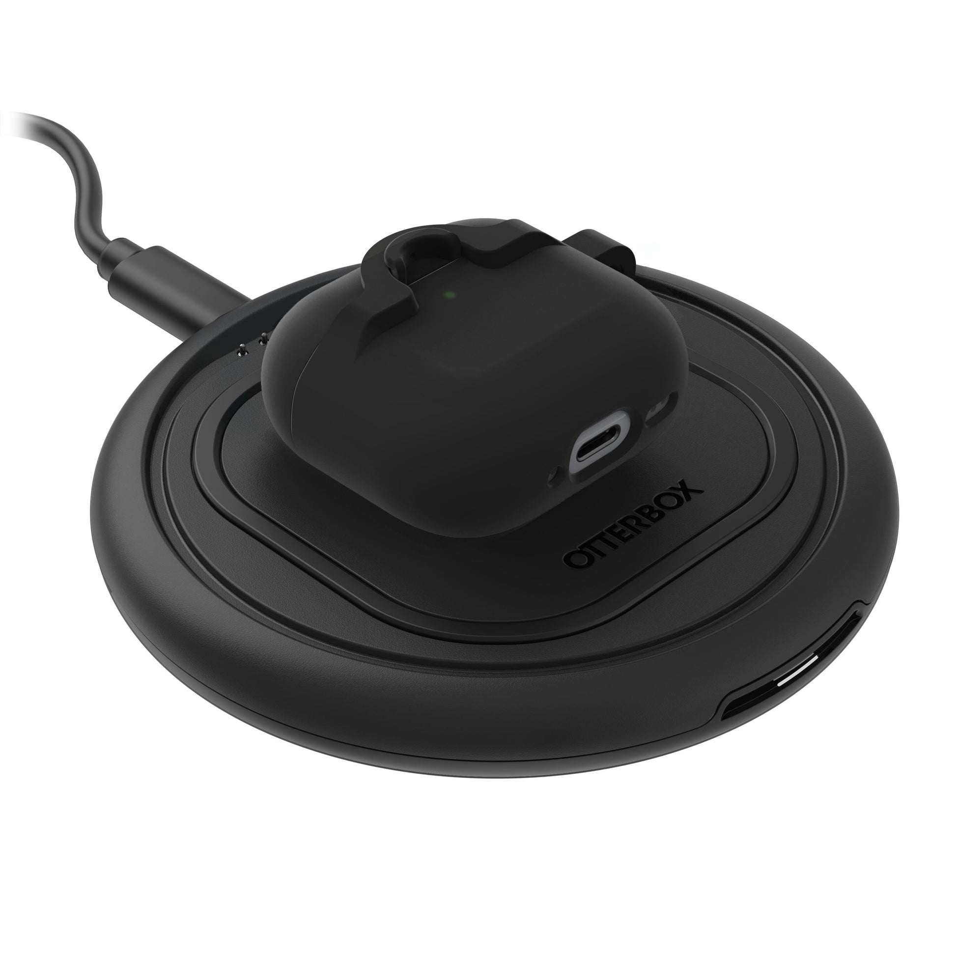 Sort trådløse earbuds i Holdbart cover til AirPods Gen 4 på rund sort Otterbox opladeplade med USB-port og kabel.