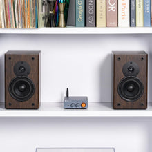 Fosi Audio forstærker Bluetooth 2x100W, stor orange knap, sammen med træsatelithøjttalere på hylde.