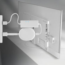 TV-bagpanel med hvid strømadapter, Mission power hub med blå LED og Google Chromecast med Google TV monteret bag skærmen.