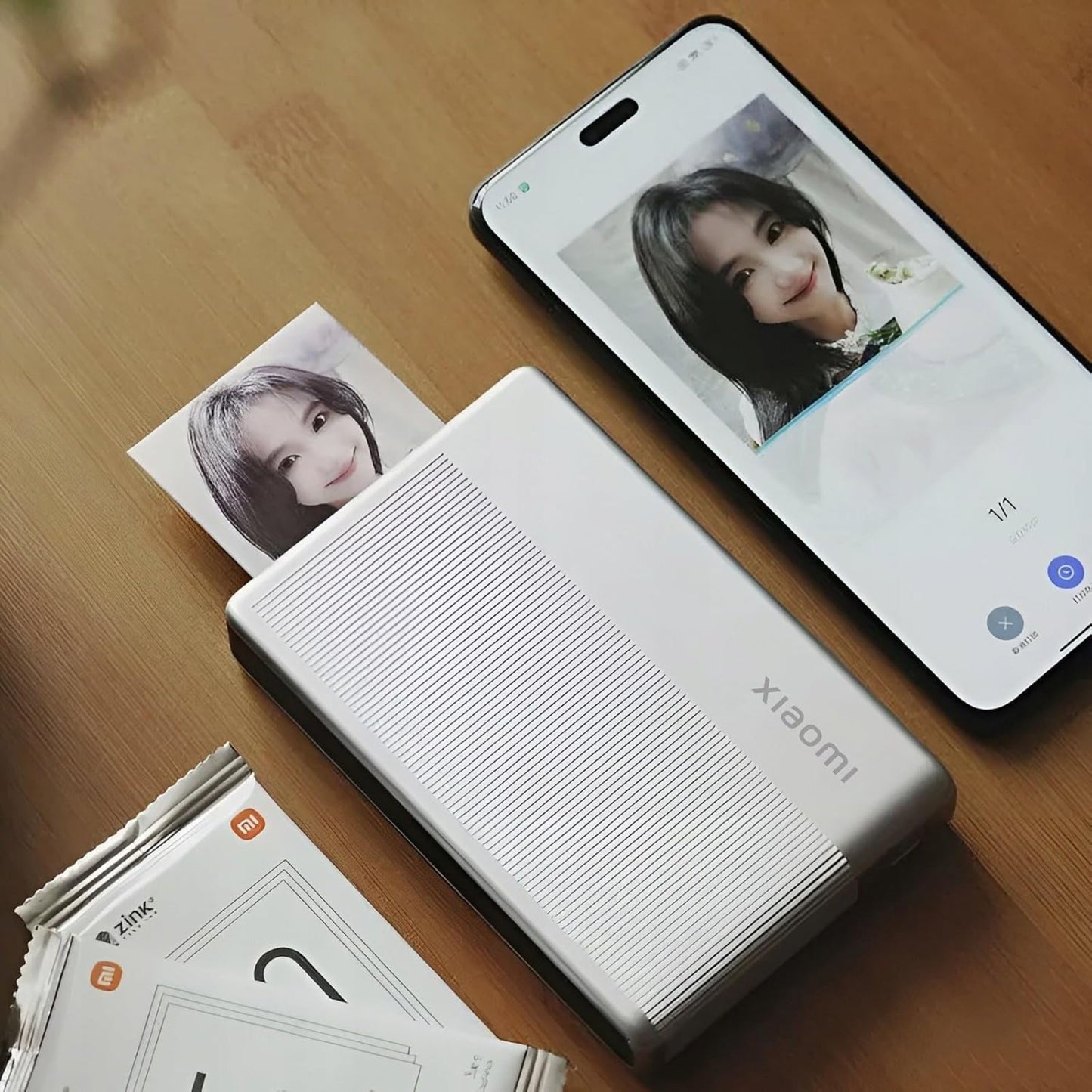 Xiaomi Bærbar fotoprinter 1S printer kvindeselfie fra smartphone med ZINK Zero Ink, fotoark og kuverter ved siden af.