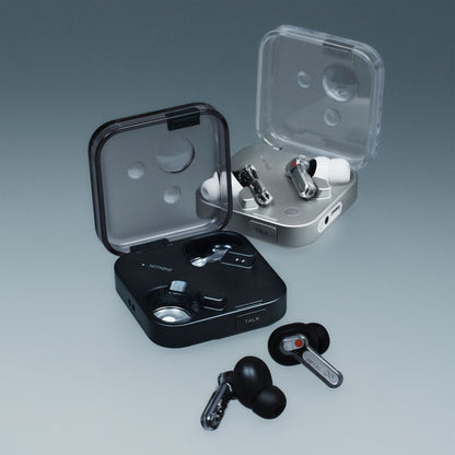 Nothing Ear (3) høretelefoner sort og hvid, hver med kvadratisk etui med transparent låg, én earbud ved siden af etuiet.