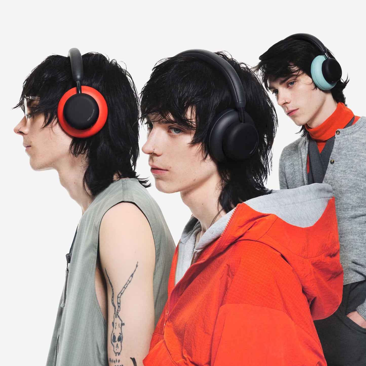 Nothing CMF Headphone Pro Hybrid ANC-hovedtelefoner i mørkegrå, rød og mintgrøn bæres af unge med mørkt, pjusket hår.