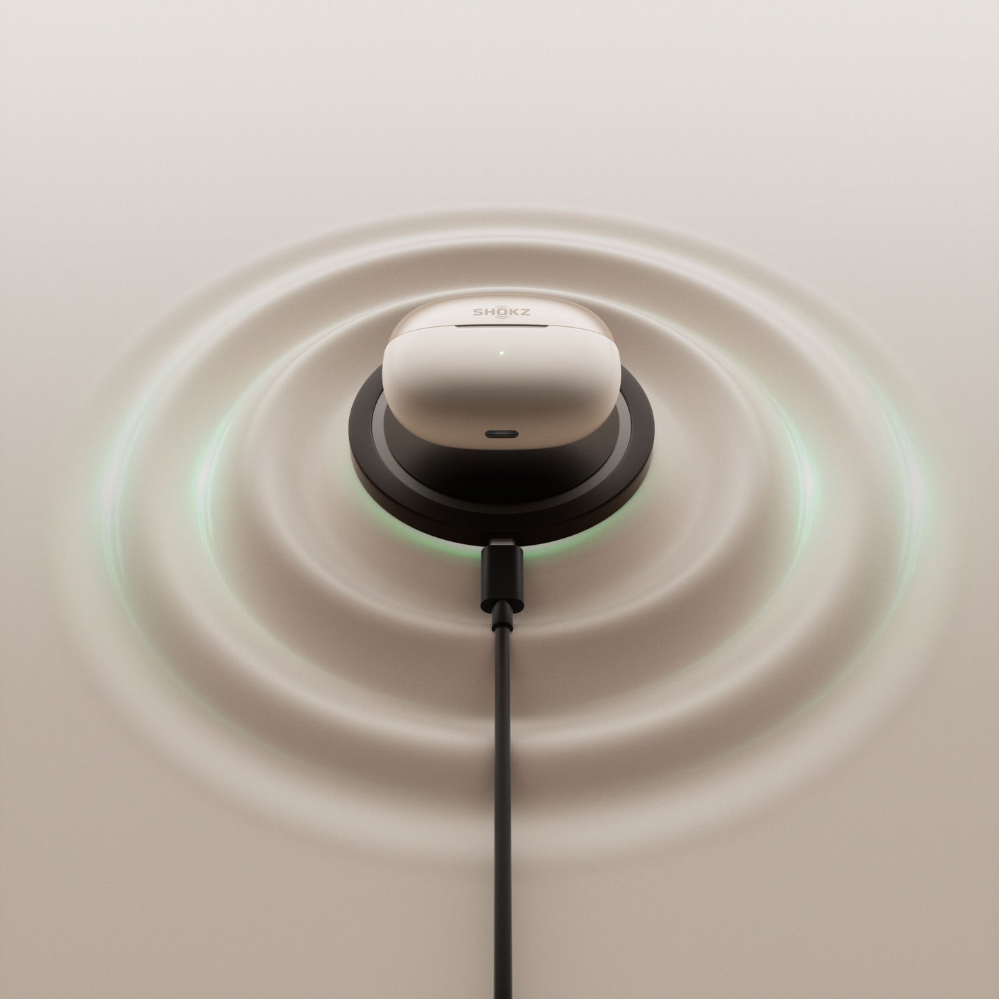Shokz OpenDots One grå trådløse åbne clip-on-hovedtelefoner i opladningsetui på sort pad med USB-C og lyseffekt.