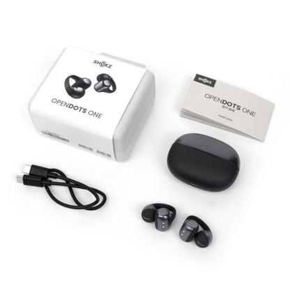 Shokz OpenDots One trådløse åbne clip-on høretelefoner sorteret med opladningsetui, USB-C kabel, brugervejledning og produktæske.