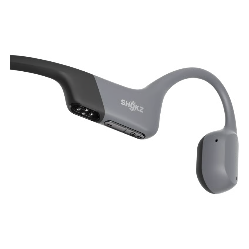 SHOKZ OpenSwim Pro trådløse hovedtelefoner i grå til svømning, synlige opladningsstik på indersiden, åben-øre-design.