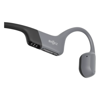 SHOKZ OpenSwim Pro trådløse hovedtelefoner i grå til svømning, synlige opladningsstik på indersiden, åben-øre-design.