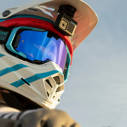 Hvid-blå motocrosshjelm med reflekterende visir, Gopro HERO actionkamera 4K monteret på toppen.