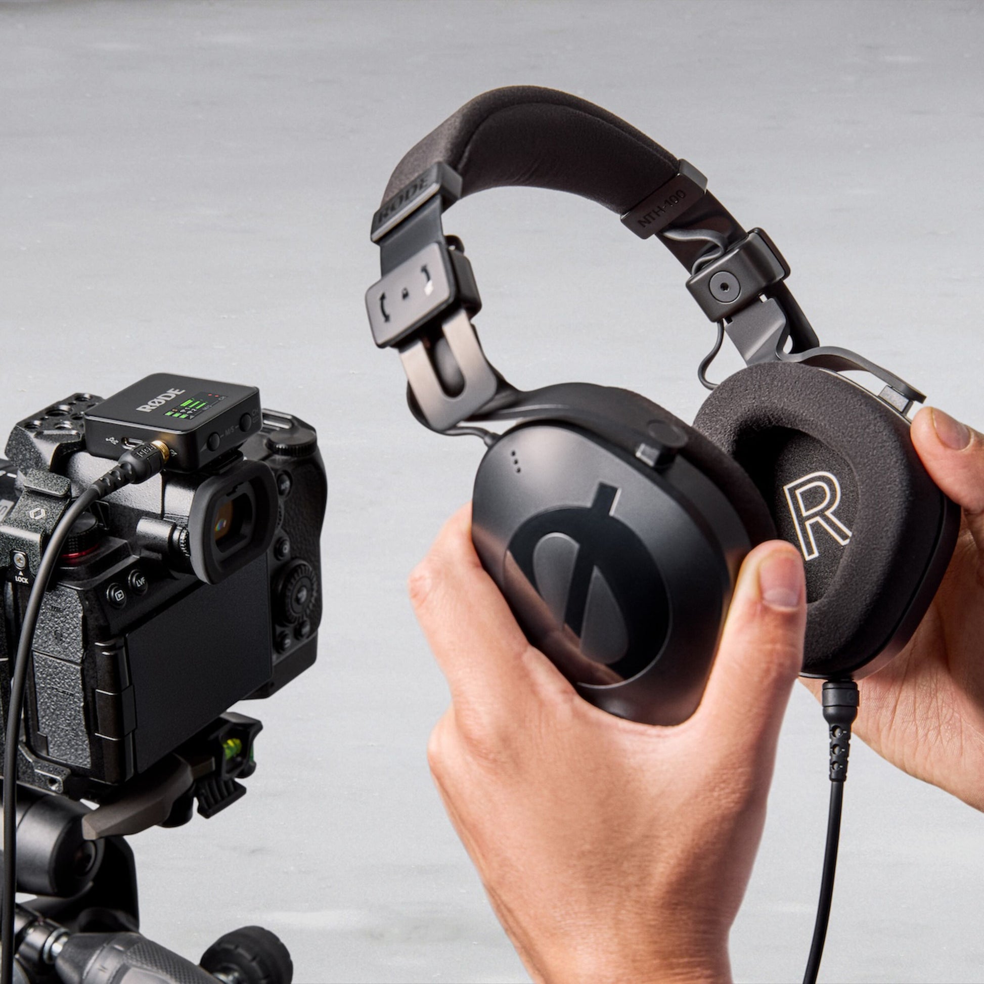Røde Trådløst GO Gen 3 mikrofonsystem monteret på kamera på stativ, sorte over-ear hovedtelefoner med "R"-mærke.