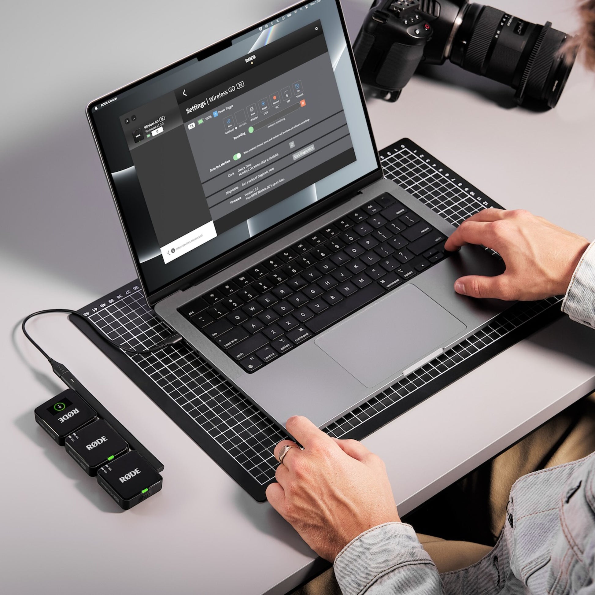Røde Trådløst GO Gen 3 mikrofonsystem tilsluttet MacBook via USB, DSLR kamera synligt på bordet.