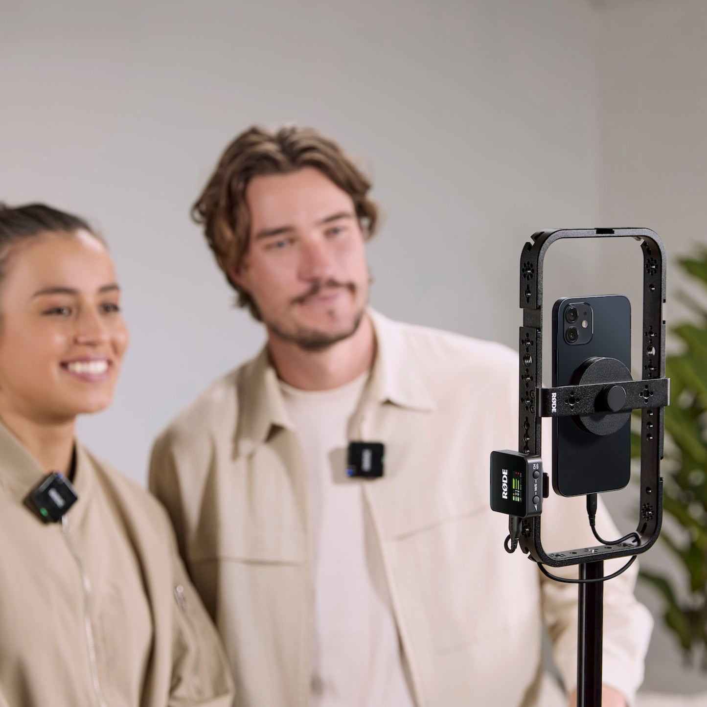 Røde Wireless GO Gen 3 mikrofonsystem påklipset til personer i beige foran smartphone på ringlys, livestream-optagelse.