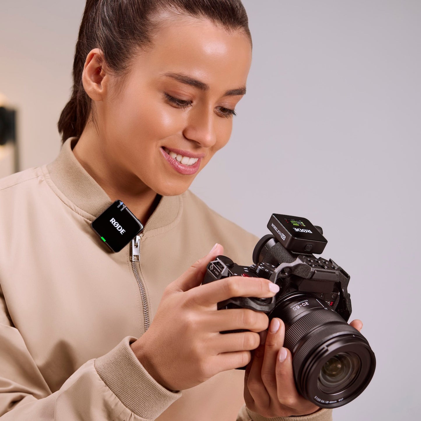 Røde Trådløst GO Gen 3 mikrofonsystem monteret på krave, enhed også på DSLR-kamera, beige jakke.