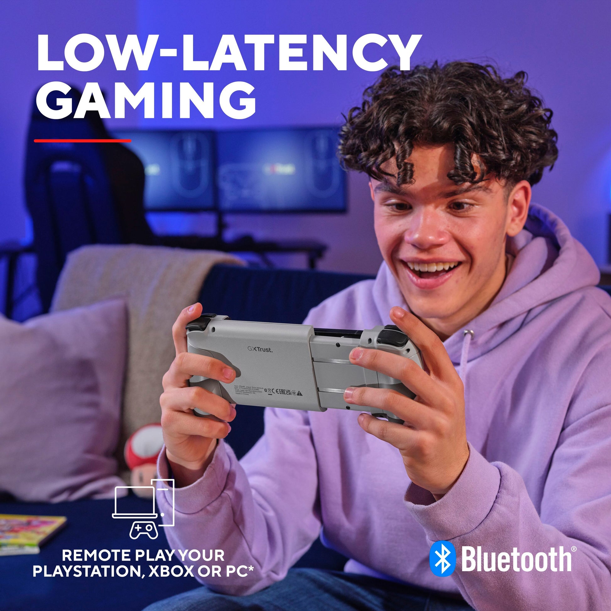 Trust GXT 735 Mylox trådløs mobilcontroller grå i brug med håndholdt gaming enhed, Bluetooth og LOW-LATENCY GAMING ikon vises.