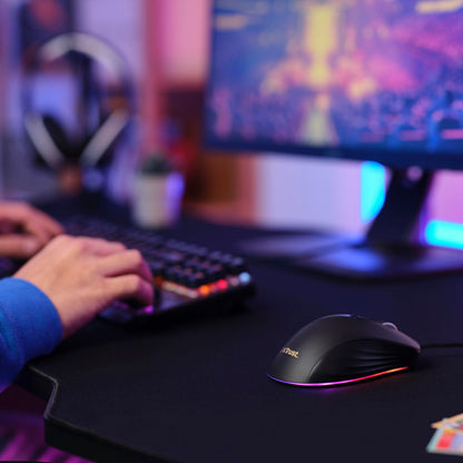 GXT 924 Ybar+ gamingmus med RGB-lys på sort musemåtte, RGB-tastatur med programmerbare taster i lilla og blå belysning.
