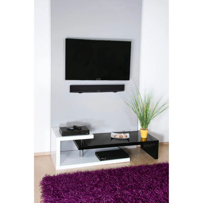 Fladskærms-tv monteret med Fleksibelt vægbeslag til soundbar, sort/hvid tv-møbel, gul potteplante, lilla tæppe.