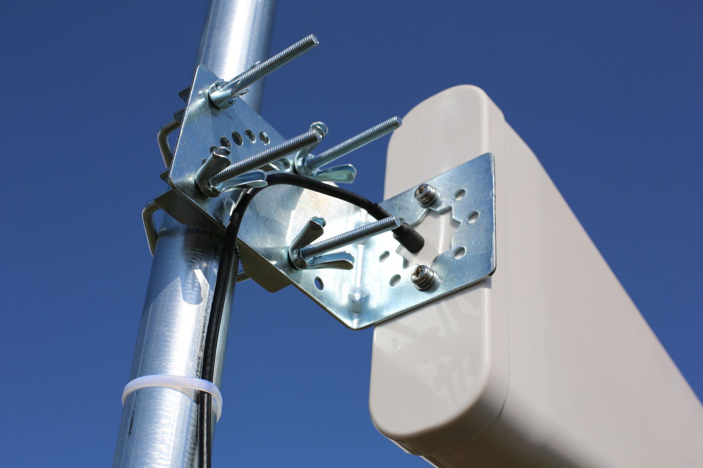 Macab Rettet 5G-antenne 11 dBi beige monteret på metalstang med bolte, sort kabel tilsluttet.