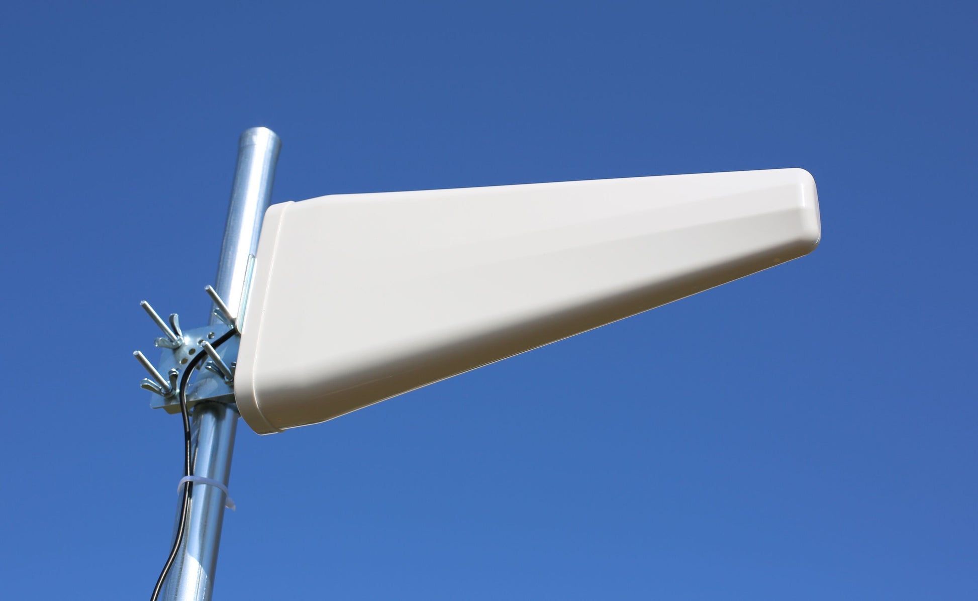 Macab Rettet 5G-antenne 11 dBi hvid trekantet, monteret på metalstang mod blå himmel.