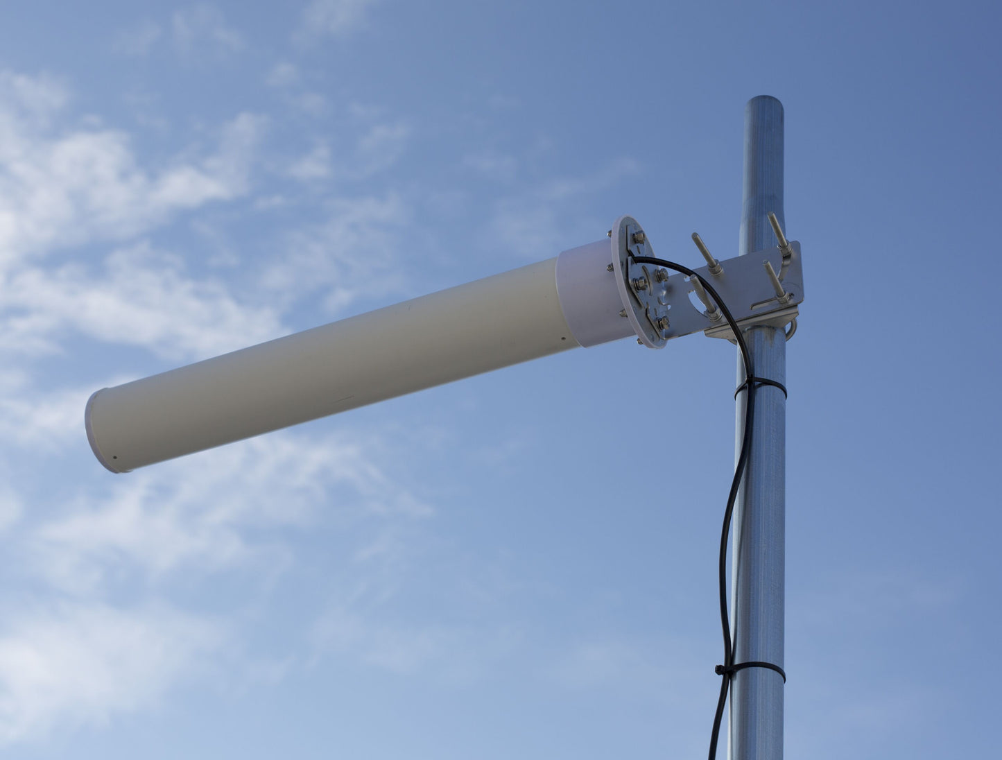 Rettet 4G-antenne 18 dBi hvid cylinder, monteret vandret på metalstang med sort SMA-han kabel fastgjort med strips.
