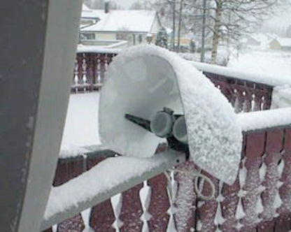 LNB-paraply Wentronic monteret på parabol på sneklædt altan, snedækkede tage i baggrunden.