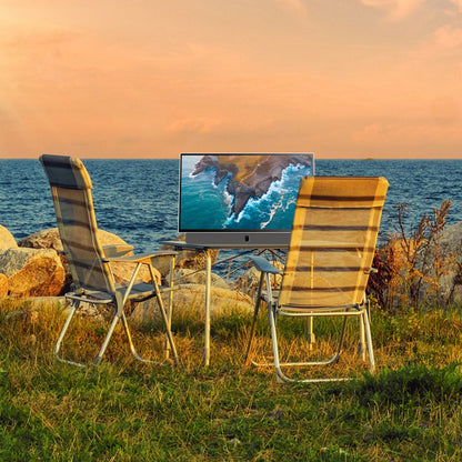 Strong METZ 24" LED bærbar TV sort, viser kystmotiv på skærmen, stående udendørs ved bord mellem to havestole.
