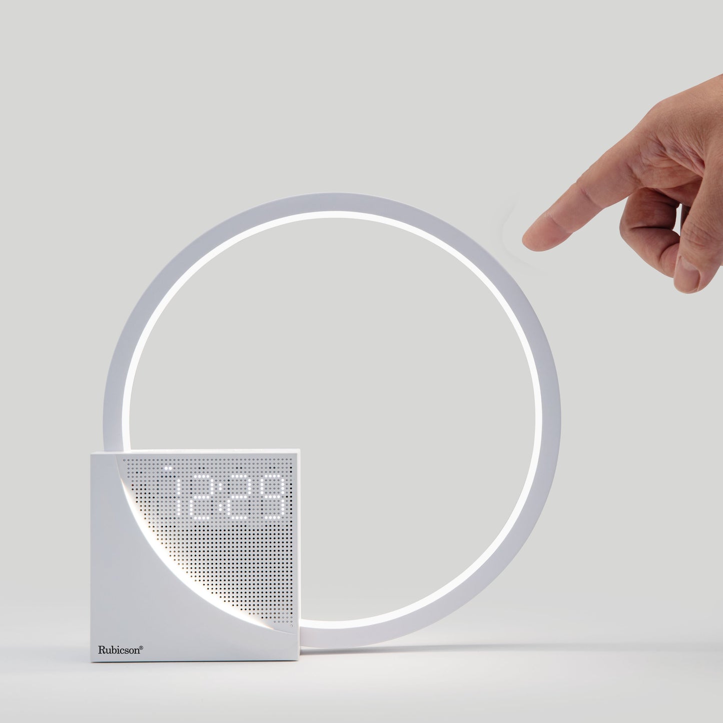 Rubicson Wake-up light vækkeur med natlampe, vises ved siden af ur der viser 12:29, hånd rækker ud efter vækkeuret.