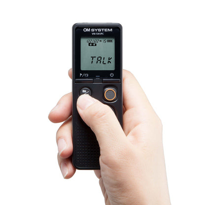 OM System VN-541PC diktafon sort, display med "TALK" og symboler, knap under skærmen trykkes med tommelfinger.