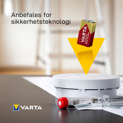 Varta Longlife Power Alkaline 9V-batteri over røgalarm, gul pil til installation, synligt Varta-logo og norsk tekst.