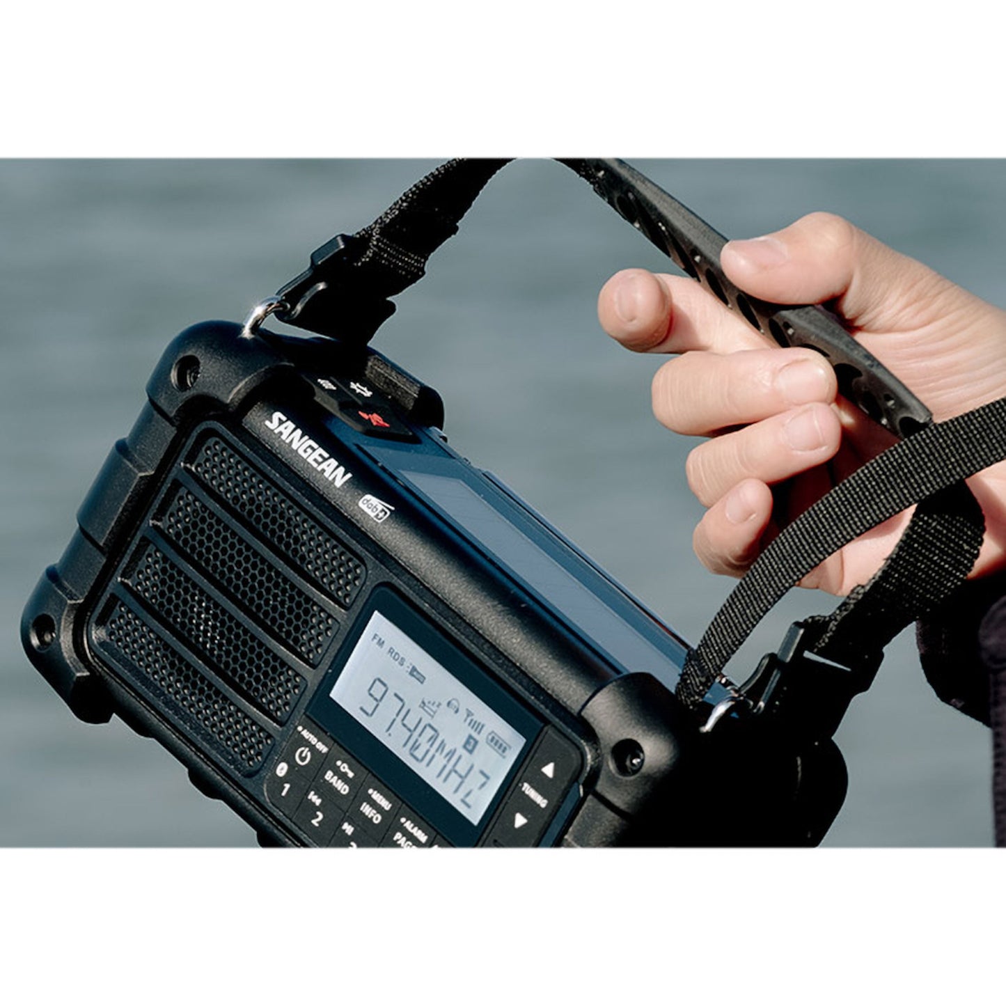 Sangean MMR-99 DAB+ sort hånddrevet radio med solceller, digitalt display viser 97,4 MHz, bærestrop.